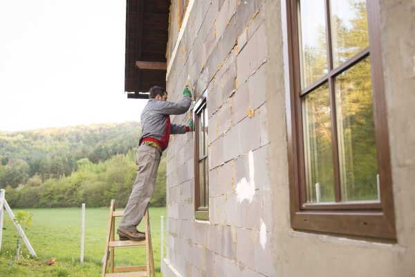 Plasterer spreading out plaster with trowel around the windows